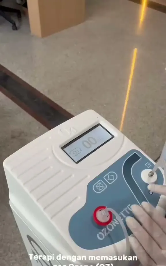 Tangan bersarung tangan mengatur panel mesin terapi ozone Ozonette