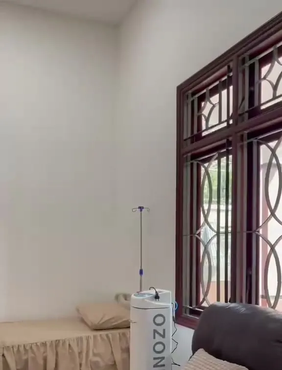 Ruang tindakan dengan kursi recliner, tempat tidur dan jendela kayu berukir